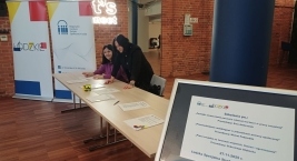 Zdjęcie przedstawia rejestracje na 3 szkolenia oraz roll -up Organizatora.
