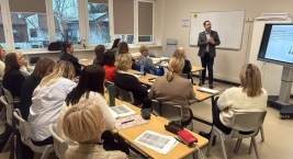 Mężczyzna wygłasza wykład do grupy osób w sali