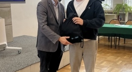 Dwaj mężczyźni stoją przed dużym ekranem