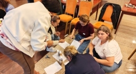 Grupa wykonuje elementy z papieru na podłodze