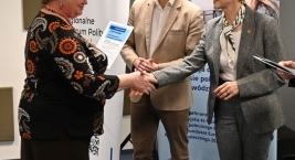 Wręczenie certyfikatu uczestniczce wydarzenia przez przedstawicieli organizatorów