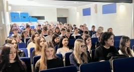 Uczniowie siedzący na widowni podczas spotkania informacyjnego dotyczącego ekonomii społecznej.